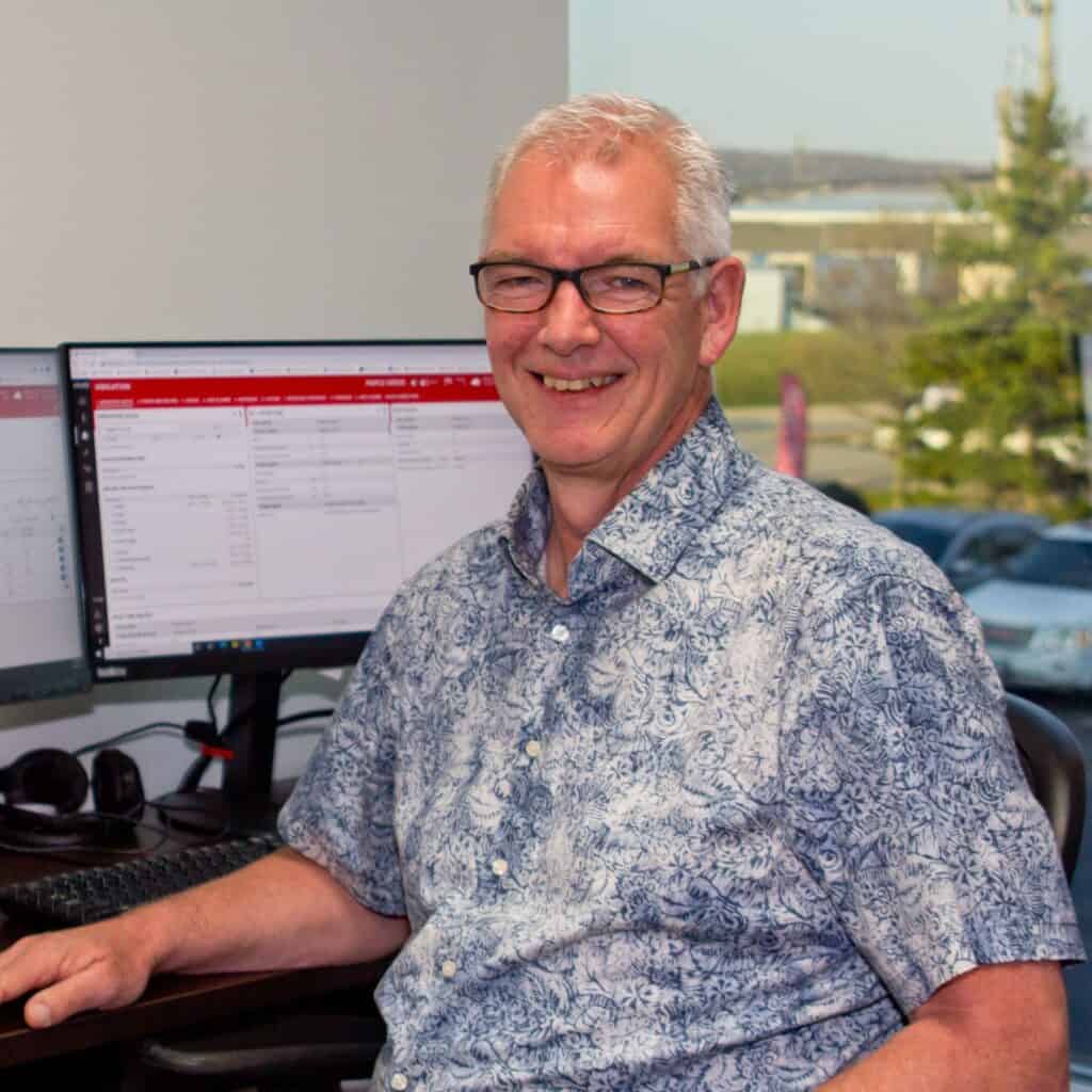 Professional headshot of Neil sitting at his desk in the CosMic Plants office