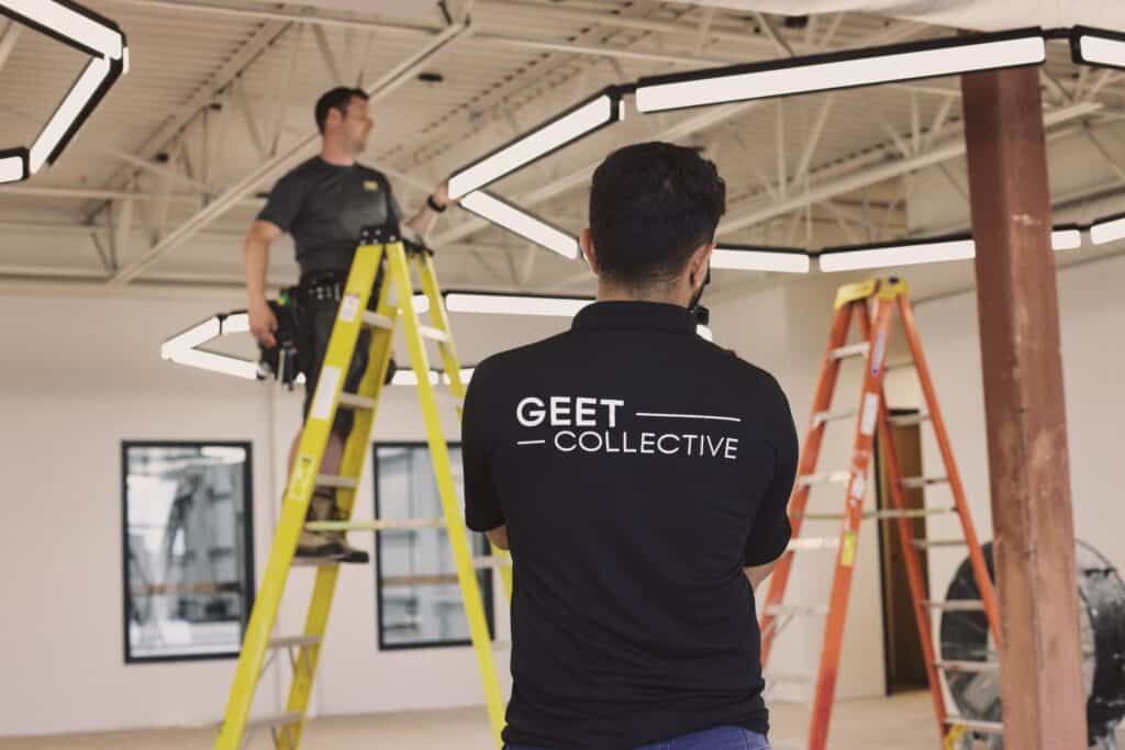 Candid shot of Geet filming a business working on the lights in a building